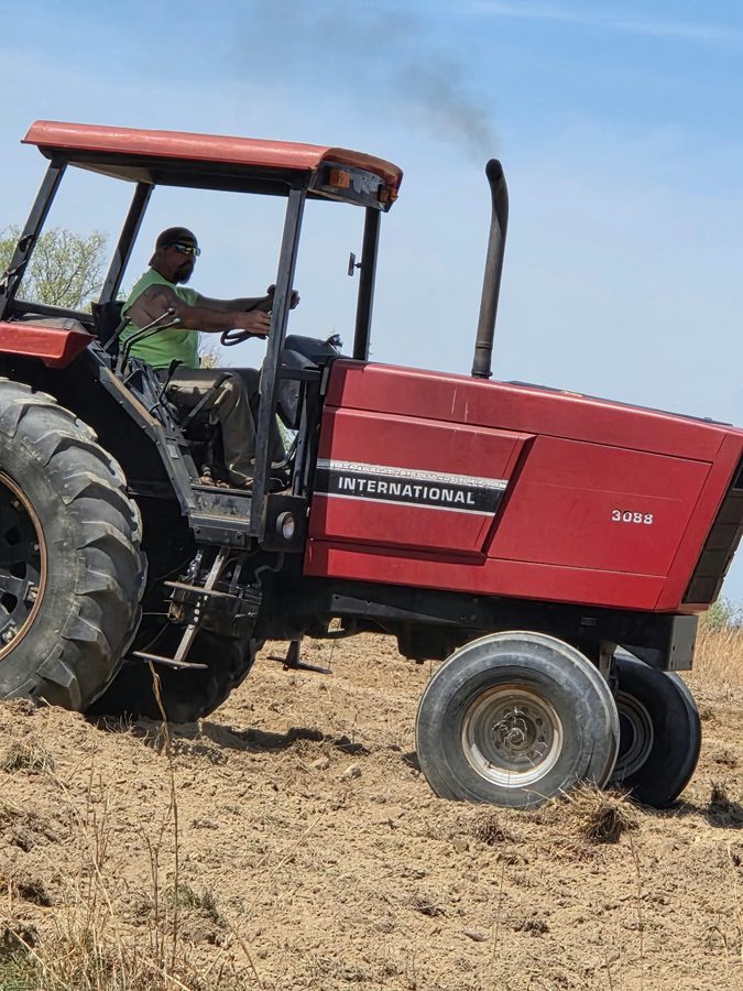 A red International tractor working the field